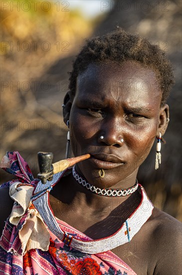 Woman from the Toposa tribe smoking a pipe