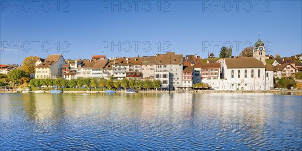 View from the banks of the Rhine over the Rhine towards the old town of Eglisau with reflection on the river water