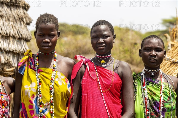 Traditional dressed girls from the Toposa tribe sitting in a grain storage