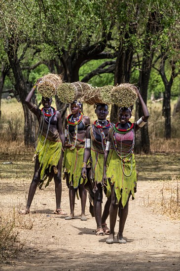 Girls with collected reeds on their heads on their way home