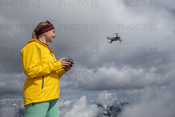 Young woman flying a drone with camera