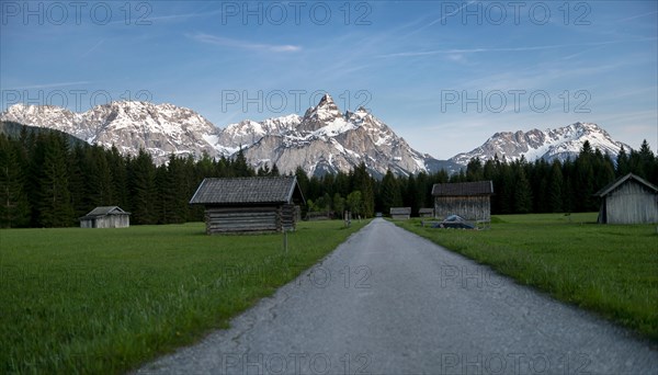 Path and meadow with hay barns