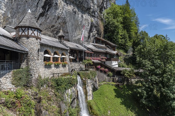 Ensemble of buildings with waterfall in front of the Saint Beatus Caves