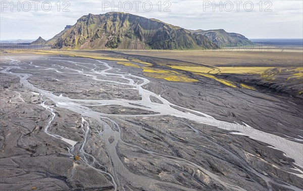 River with fanned out branches through black lava sand