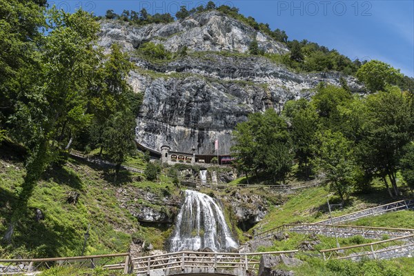 Ensemble of buildings with waterfall in front of the Saint Beatus Caves