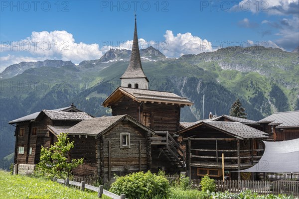 Historic village centre with wooden Valais houses and tower of the Seven Joys of Mary parish church