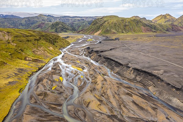 River with fanned out branches through black lava sand