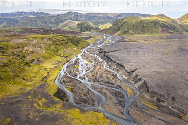 River with fanned out branches through black lava sand