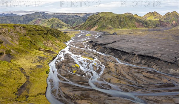 River with fanned out branches through black lava sand