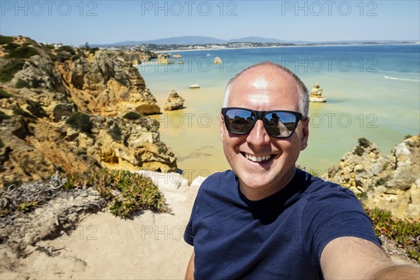 Tourist taking photo of himself at famous Ponta da Piedade