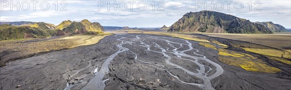 River with fanned out branches through black lava sand