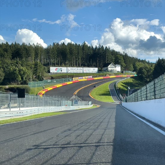 View from a moving race car onto the Eau Rouge bend and Raidillon slip road of the Circuit de Spa-Francorchamps