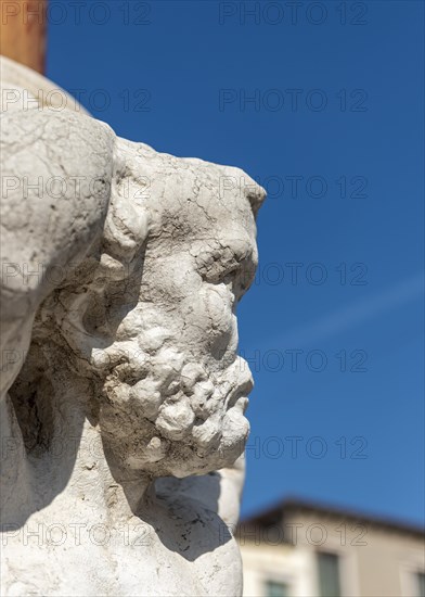 Noseless Telamon statue on city flagpole