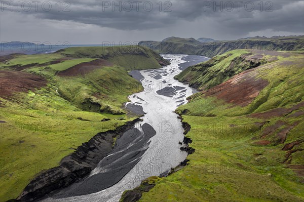 River with fanned out branches through black lava sand