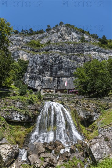 Ensemble of buildings with waterfall in front of the Saint Beatus Caves