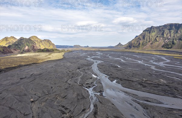 River with fanned out branches through black lava sand