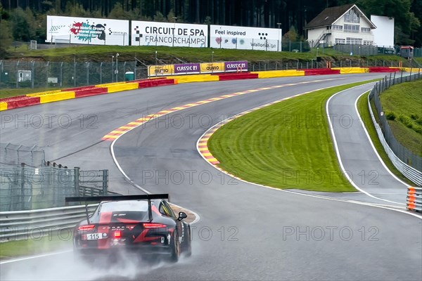 Porsche GT3 Cup race car hits wet track at Eau Rouge corner from Raidillon slip road
