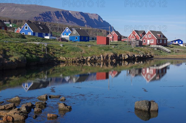 Simple wooden houses reflected in a body of water