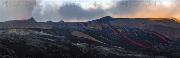 Erupting volcano with lava fountains and lava field