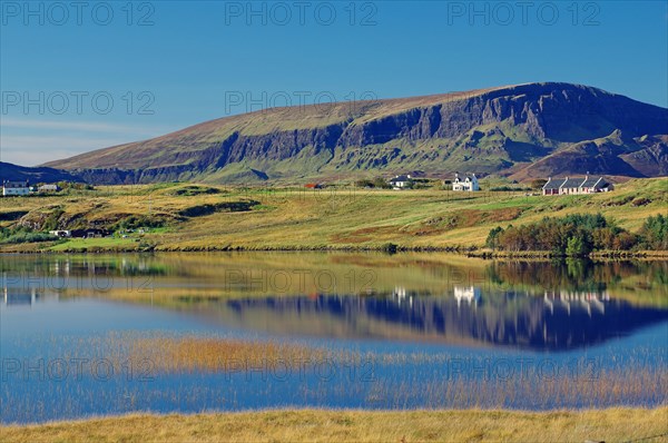 Mountains and houses reflected in a loch