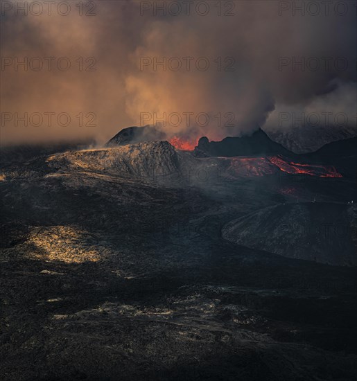 Erupting volcano with lava fountains and lava field