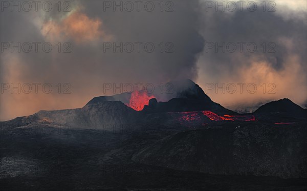 Erupting volcano with lava fountains and lava field