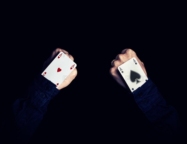 Two fists with hearts and spades aces in the hole