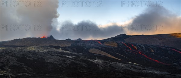 Erupting volcano with lava fountains and lava field