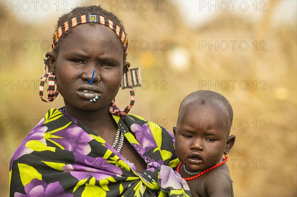 Woman with her child before her hut