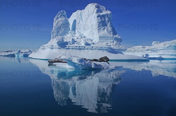 Huge iceberg reflected in a fjord