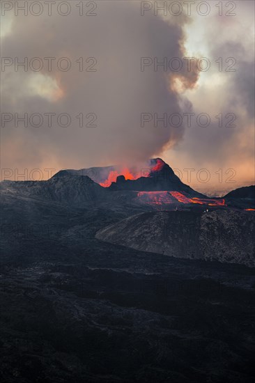 Erupting volcano with lava fountains and lava field