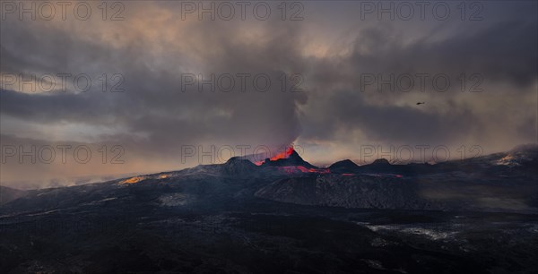 Erupting volcano with lava fountains and lava field