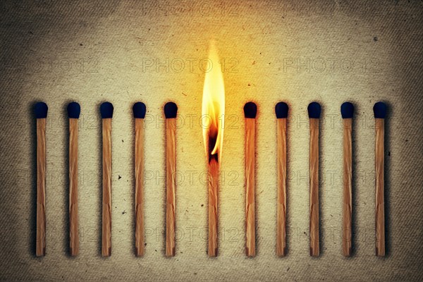 Burning match standing middle a row of whole