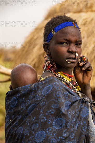 Woman with her child before her hut