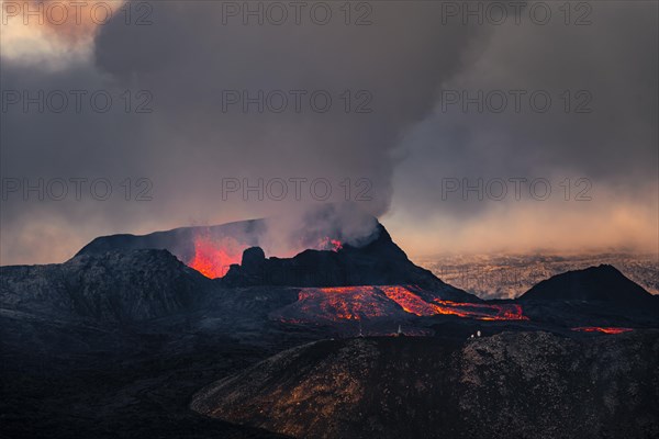 Erupting volcano with lava fountains and lava field