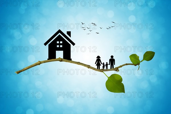 Tree branch with silhouettes of house and family