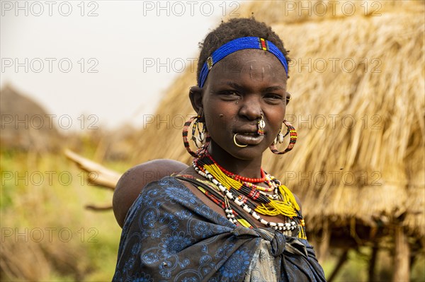 Woman with her child before her hut