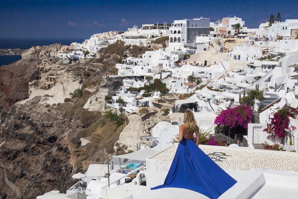Woman in a blue dress looks over the place Imerovigli
