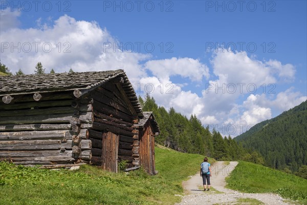 Hikers in front of old haystacks