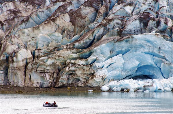 Small boat in front of glacier