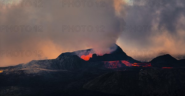 Erupting volcano with lava fountains and lava field