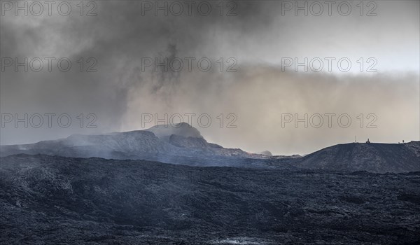 Erupting volcano with lava field