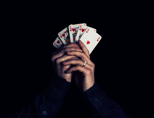 Man hands holding playing cards with the strongest combination