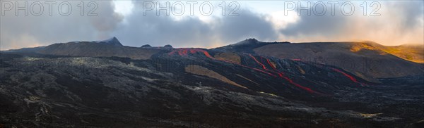 Erupting volcano with lava fountains and lava field