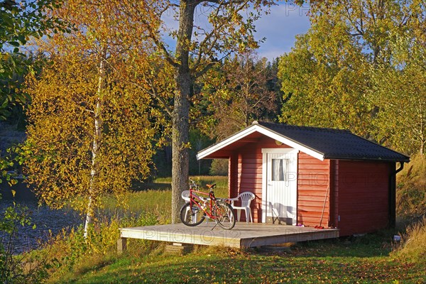 Bicycle standing in front of small hut by a lake