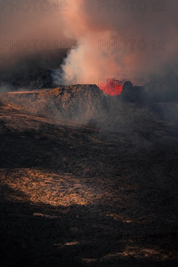 Erupting volcano with lava fountains and lava field