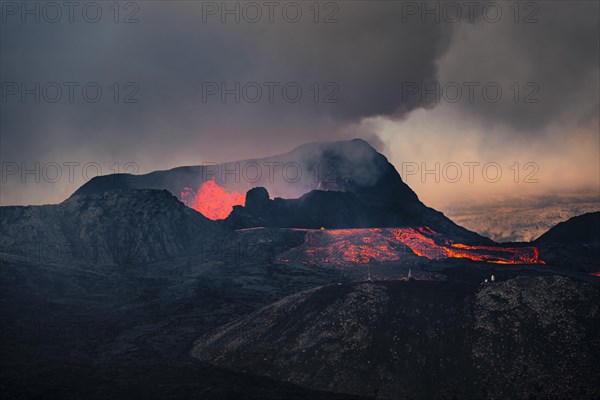 Erupting volcano with lava fountains and lava field