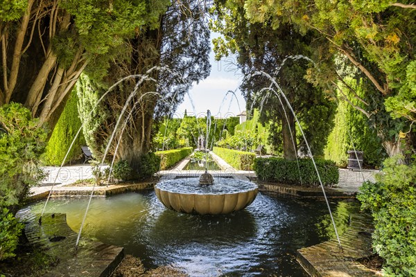 Fountain and trees in Generalife garden in Arabic palace complex called Alhambra in Granada