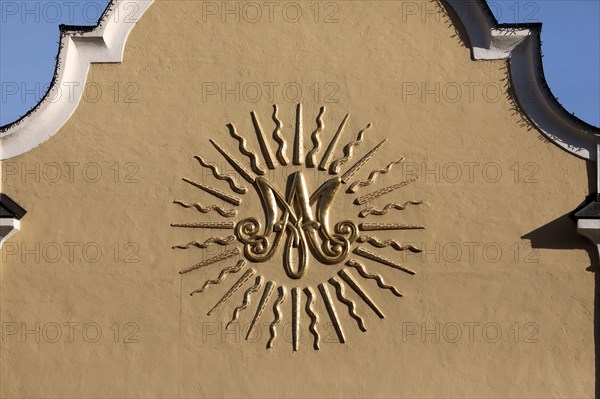 Baroque monogram of the Virgin Mary on the facade of a church