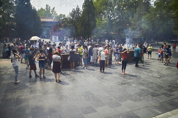 Tourists with incense sticks at the Lama Temple